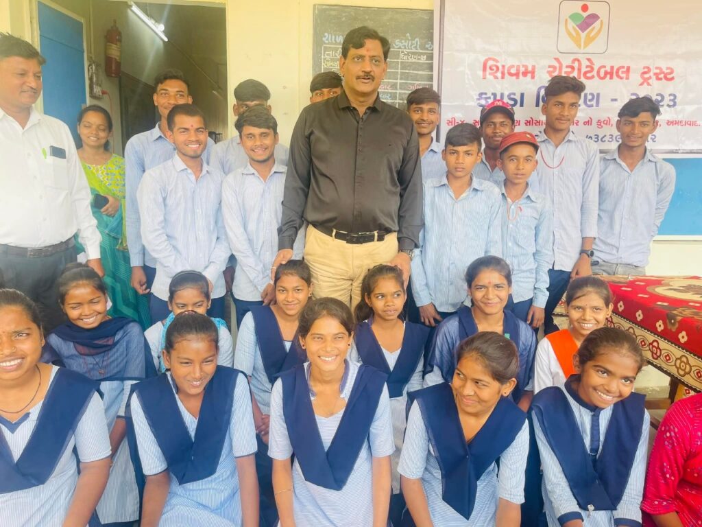 Shivam Charitable Trust distributing school bags, books, and educational kits to underprivileged children in Gujarat.