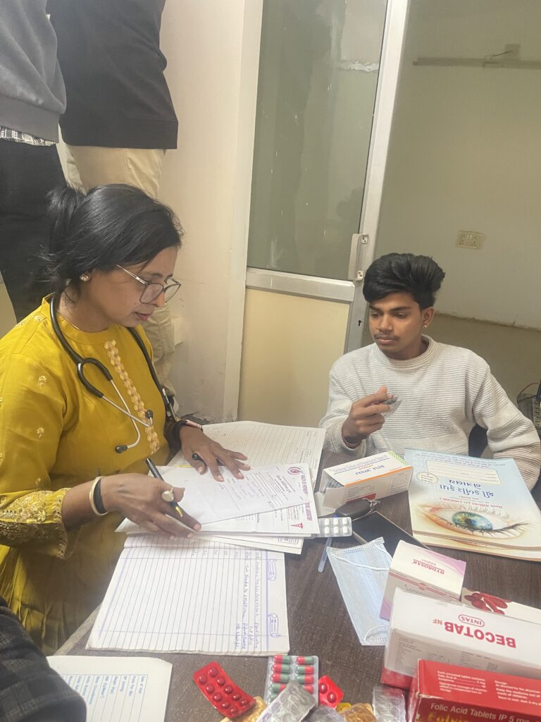 Child receiving medical consultation during a Sickle Cell healthcare camp organized by Shivam Charitable Trust in Dahod