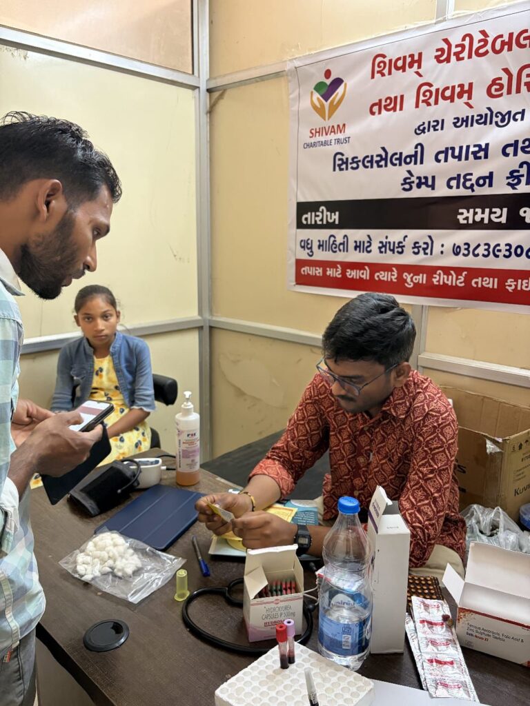 Healthcare worker conducting a Sickle Cell patient assessment during a free health camp in Dahod organized by Shivam Charitable Trust.