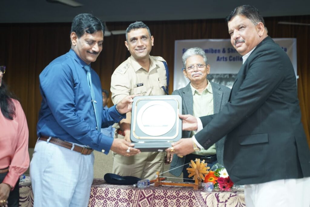 Dr. Prakash H. Kurmi presenting a certificate to a student during the Diabetes Awareness Program at Smt. Laxmiben & Shree Chimanlal Mehta Arts College organized by Shivam Charitable Trust.