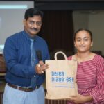 Dr. Prakash H. Kurmi presenting a certificate to a student during the Diabetes Awareness Program at Smt. Laxmiben & Shree Chimanlal Mehta Arts College organized by Shivam Charitable Trust.