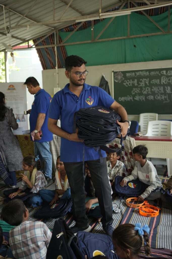 Shivam Charitable Trust and Rasna distribute approximately 450 bags in Patan, Gujarat, as part of a community welfare initiative.