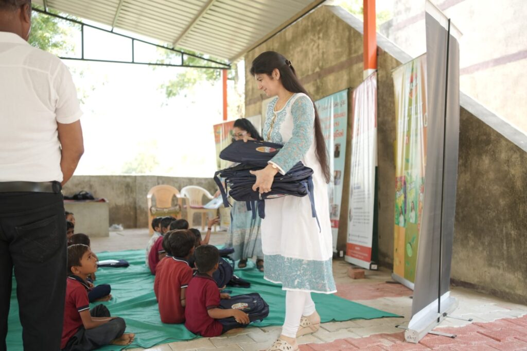 Shivam Charitable Trust and Rasna distribute approximately 450 bags in Patan, Gujarat, as part of a community welfare initiative.